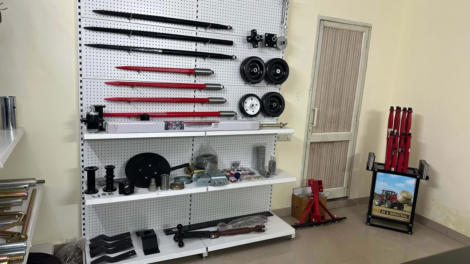 Showroom wall with bale spears, rotary cutter wheels, jacks and top links